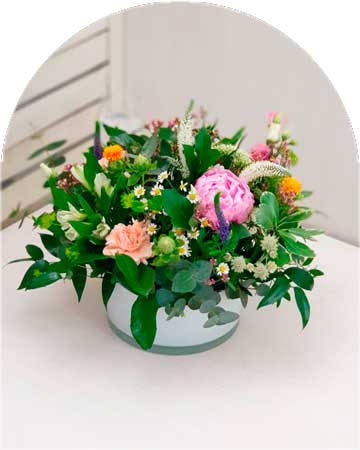 Imagen de un centro nuestro de flores frescas con peonías y variedad de flores silvestres, perfecto para decorar tu hogar en Ciudad Real